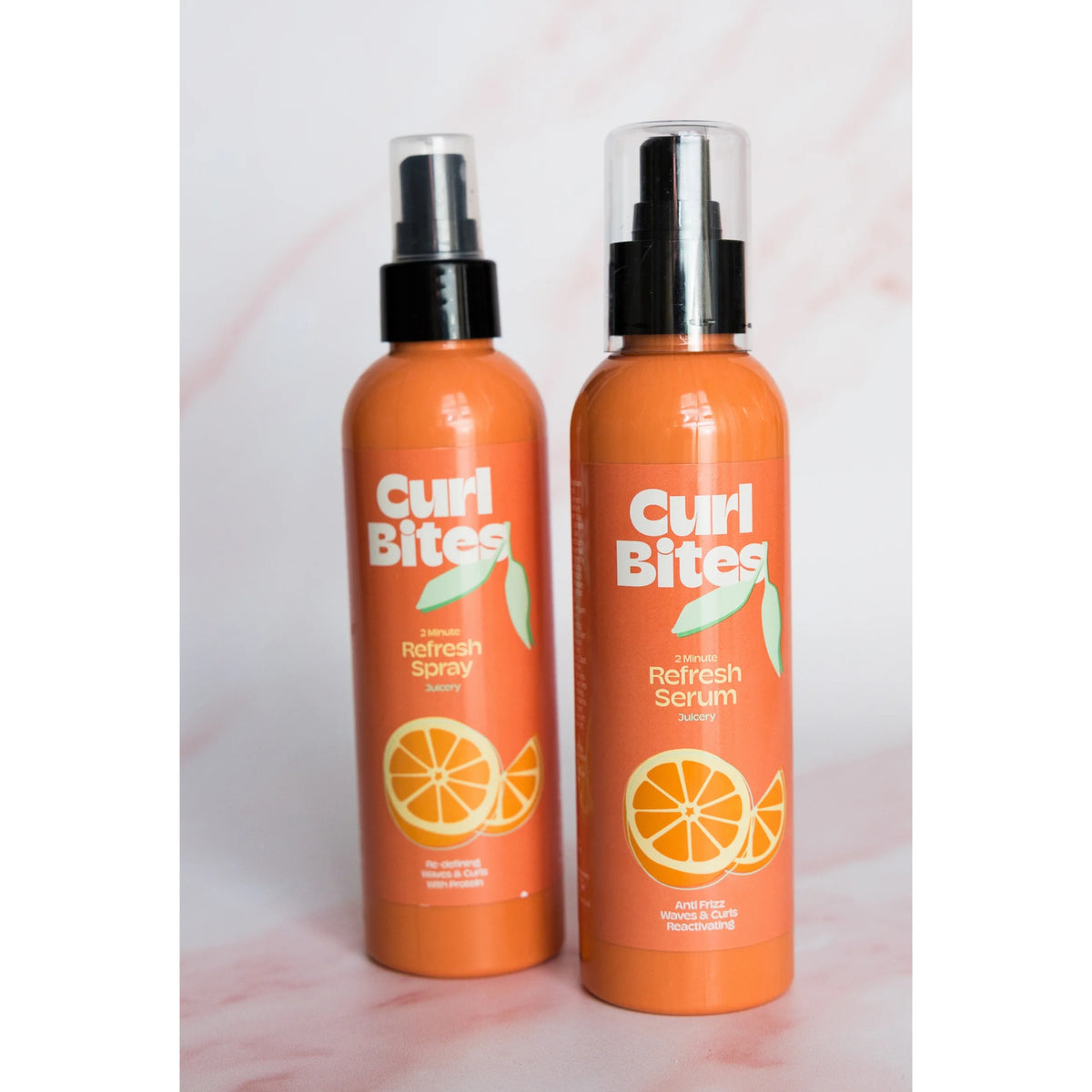 To orange Curl Bites flasker: 2 Minute Refresh Spray og Refresh Serum med appelsinmotiv.